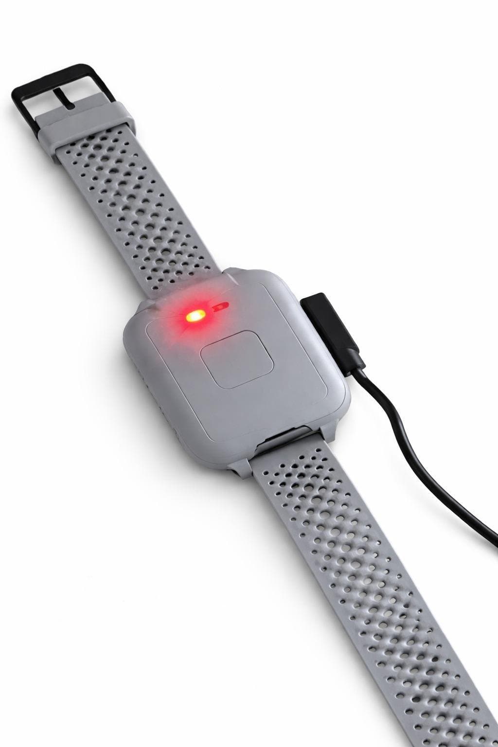 Das GCARE Armband am Ladekabel, die Anzeigeleuchte leuchtet